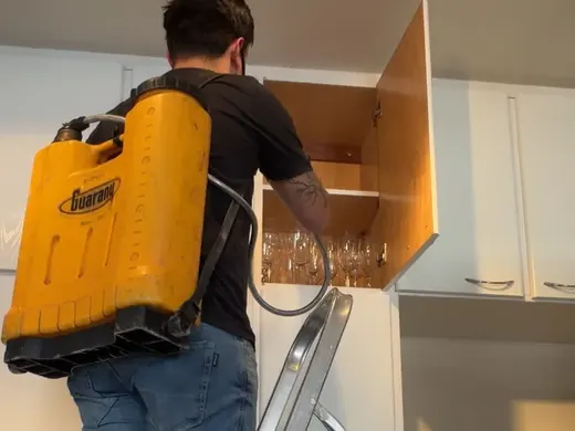 Técnico aplicando injeção em armário com contato na alvenaria